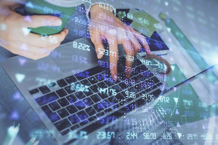 Double exposure of woman hands typing on computer and forex chart hologram drawing. Stock market...