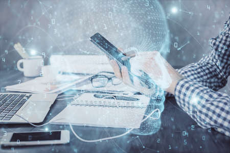 Double exposure of mans hand holding and using a digital device and brain hologram drawing. Data...