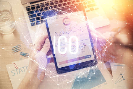 Double exposure of mans hands holding and using a phone and crypto currency blockchain theme...