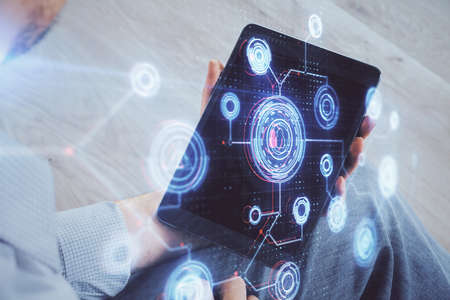 Double exposure of mans hand holding and using a digital device and data theme drawing. Technology...