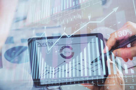 Double exposure of mans hands holding and using a phone and financial chart drawing. Market analysis...