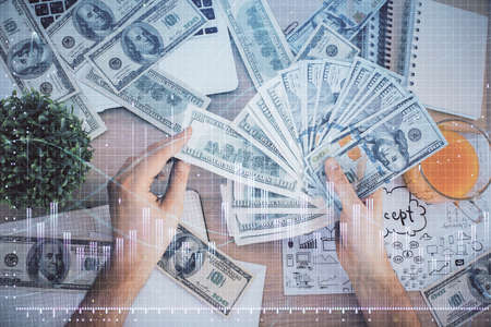 Multi exposure of financial graph drawing hologram and USA dollars bills and man hands. Analysis...