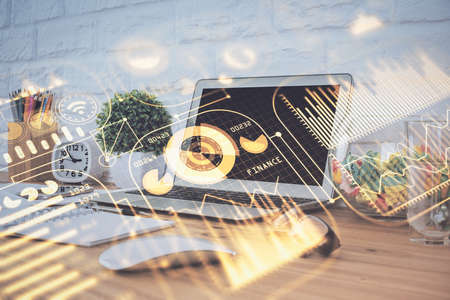 Computer on desktop in office with technology theme hologram. Double exposure. Tech concept.