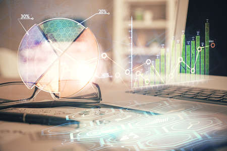 Financial chart hologram with glasses on the table background. Concept of business. Double exposure.