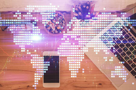 Double exposure of business theme hologram over desktop with phone. Top view. Mobile international...