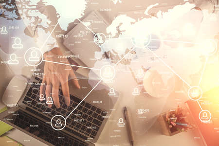 Double exposure of mans hands typing over computer keyboard and social network theme hologram drawing. Top view. People connection web concept.の写真素材