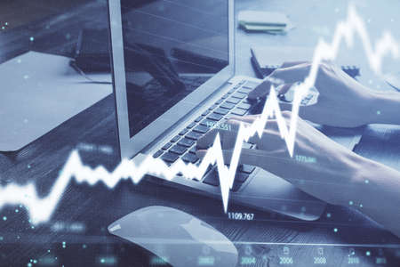 Double exposure of woman hands typing on computer and forex chart hologram drawing. Stock market...