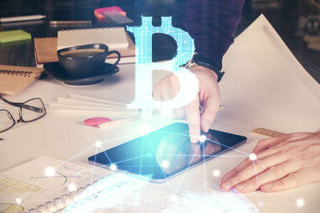 Double exposure of mans hands holding and using a phone and crypto currency blockchain theme...