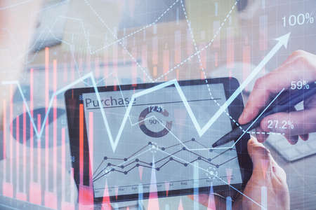 Double exposure of mans hands holding and using a phone and financial chart drawing. Market analysis...