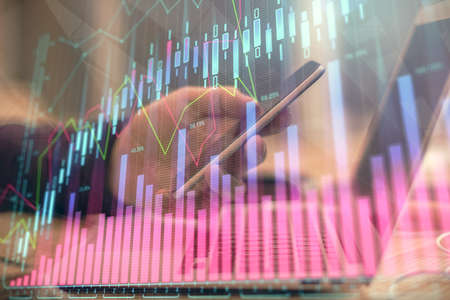 Double exposure of mans hands holding and using a phone and financial graph drawing. Analysis...