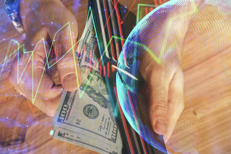 Multi exposure of forex graph drawing hologram and USA dollars bills and man hands. Technical...