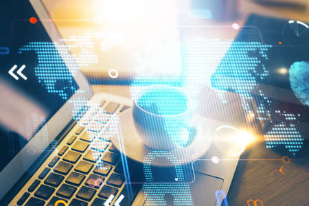 Double exposure of desktop with computer and world map hologram. International data network concept.