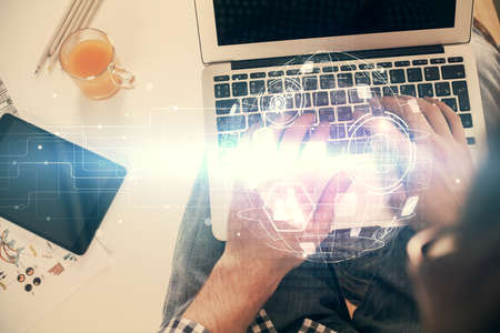 Double exposure of mans hands typing over computer keyboard and social network theme hologram...