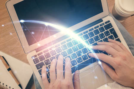 Double exposure of mans hands typing over computer keyboard and social network theme hologram...