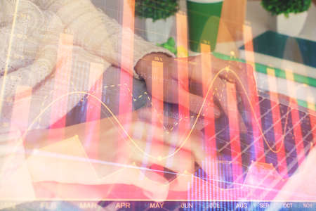 Double exposure of woman hands typing on computer and forex chart hologram drawing. Stock market...
