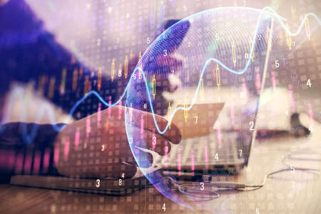 Double exposure of mans hands holding and using a phone and financial graph drawing. Analysis...