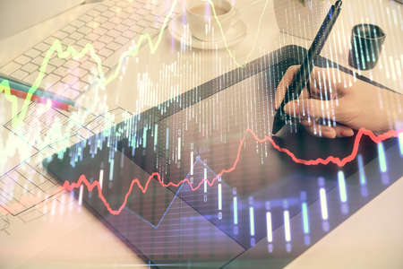 Double exposure of financial graph sketch hologram and woman holding and using a mobile device....