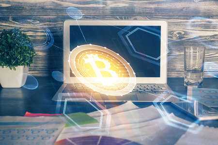 Multi exposure of blockchain theme hologram and table with computer background. Concept of bitcoin crypto currency.の写真素材