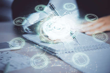 Social network theme hologram over hands taking notes background. Concept of global international...