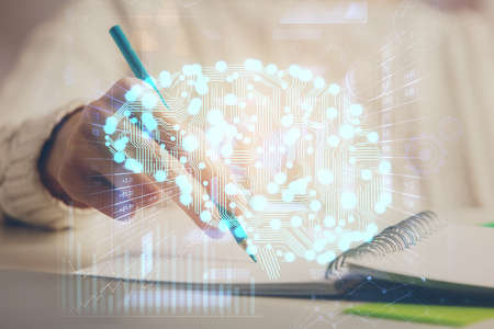 Multi exposure of writing hand on background with brain hologram. Concept of self learning.