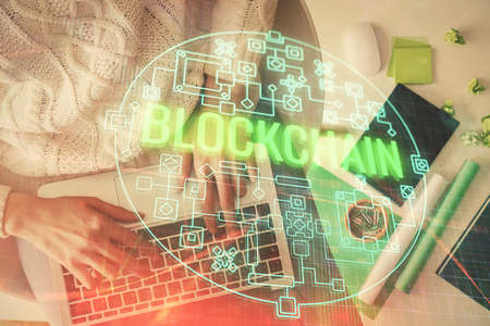 Double exposure of woman hands working on computer and blockchain theme hologram drawing. Top View....