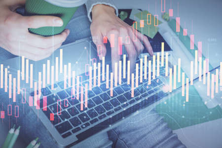 Double exposure of woman hands typing on computer and forex chart hologram drawing. Stock market...