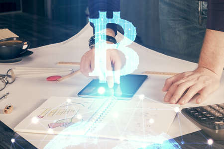 Double exposure of mans hands holding and using a phone and crypto currency blockchain theme...