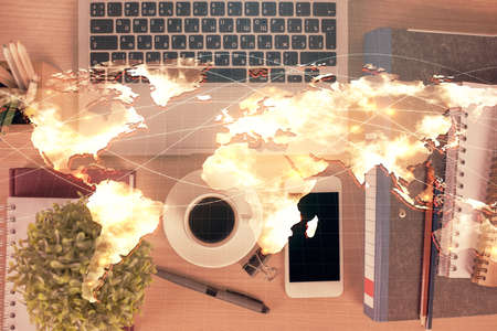 Double exposure of business theme hologram over desktop with phone. Top view. Mobile international trade connection concept.の写真素材