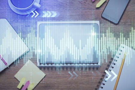 Double exposure of forex chart hologram over desktop with phone. Top view. Mobile trade platform...