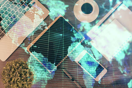 Double exposure of business theme hologram over desktop with phone. Top view. Mobile international trade connection concept.の写真素材