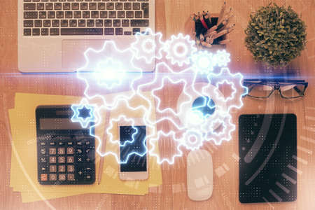 Double exposure of business theme hologram over desktop with phone. Top view. Mobile international...