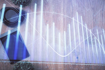 Multi exposure of financial chart hologram over desktop with phone. Top view. Mobile trade platform...