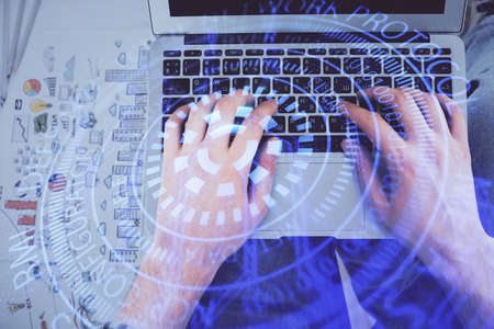 Multi exposure of mans hands typing over computer keyboard and data theme hologram drawing. Top...