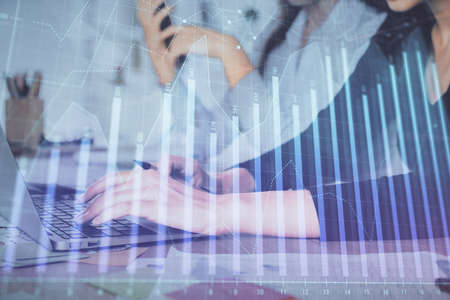 Multi exposure of woman hands typing on computer and financial graph hologram drawing. Stock market analysis concept.の写真素材