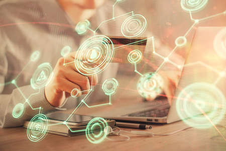 Double exposure of man hands holding a credit card and social network theme drawing. Digital finance and E-commerce concept.の写真素材