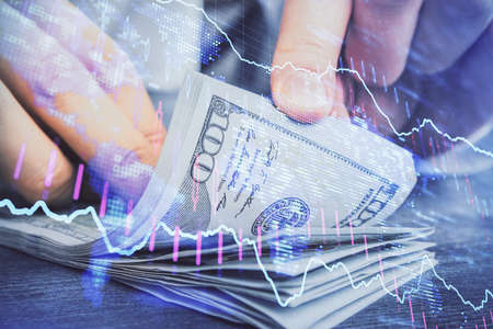 Multi exposure of forex graph drawing hologram and USA dollars bills and man hands. Technical...
