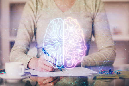 Double exposure of writing hand on background with brain hologram. Concept of learning.