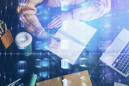 Double exposure of writing hands on background with data solution hologram on front. Technology...