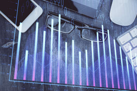 Multi exposure of forex graph hologram over desktop with phone. Top view. Mobile trade platform...