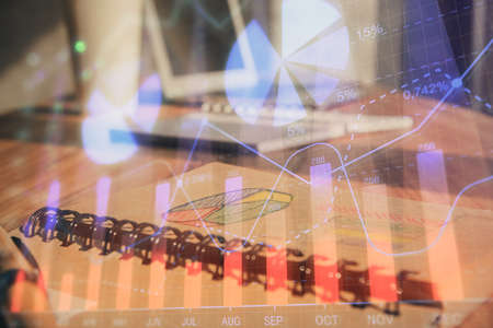Double exposure of financial graph drawings and desk with open notebook background. Concept of forex...