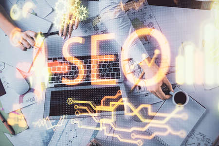 Double exposure of man and woman working together and seo drawing hologram. Technology concept. Computer background.の写真素材