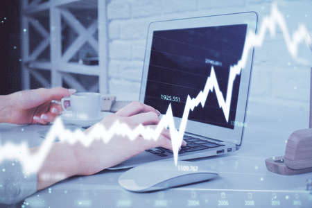 Multi exposure of woman hands typing on computer and forex chart hologram drawing. Stock market...