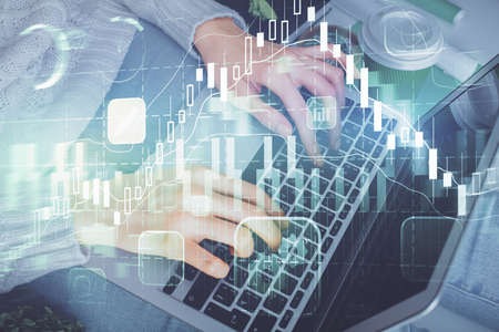 Double exposure of woman hands typing on computer and forex chart hologram drawing. Stock market...
