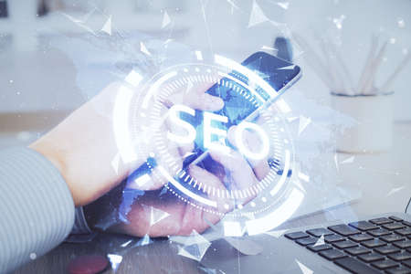 Multi exposure of mans hands holding and using a digital device and seo drawing. search optimization...