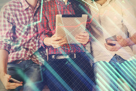 Double exposure of forex graph drawing and man and woman working together holding and using a mobile...