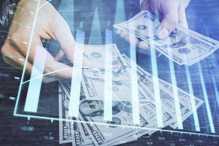 Multi exposure of financial graph drawing hologram and USA dollars bills and man hands. Analysis...