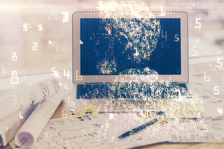 Computer on desktop in office with technology theme hologram. Multi exposure. Tech concept.