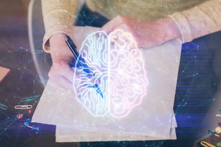Double exposure of writing hand on background with brain hologram. Concept of learning.