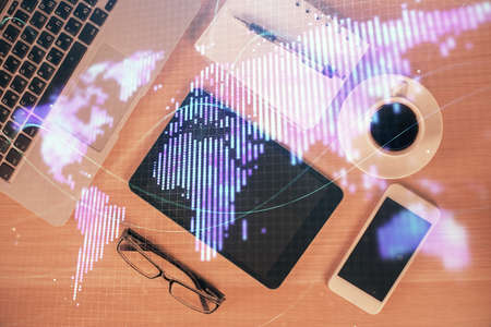 Double exposure of business theme hologram over desktop with phone. Top view. Mobile international trade connection concept.の写真素材