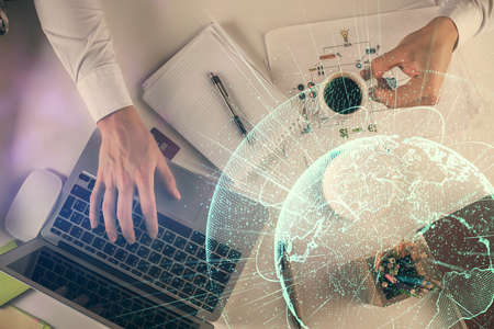 Double exposure of mans hands typing over computer keyboard and social network theme hologram...